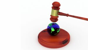 Martello da tribunale sopra ad una sfera che rappresenta il mondo