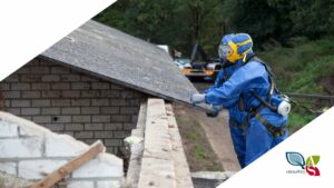 Due lavoratori che rimuovo amianto da un tetto, con tuta e autorespiratore