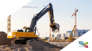 Cantiere con escavatori in primo piano, gru e grattacieli sullo sfondo